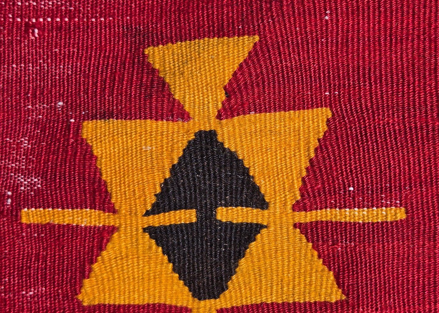 Hands-on-hips motif woven in a kilim